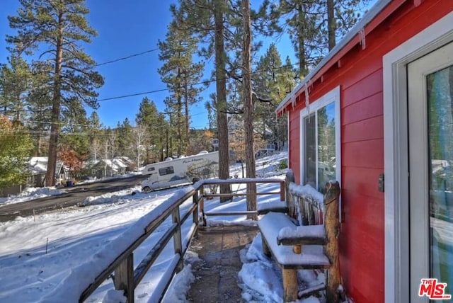 snow covered patio featuring a balcony