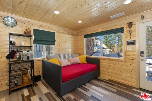 bedroom with multiple windows, wood walls, wooden ceiling, and hardwood / wood-style flooring