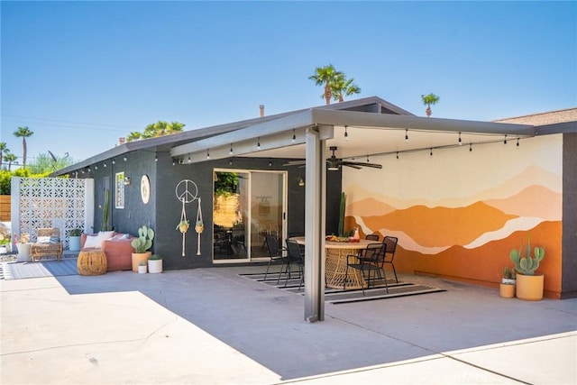 back of property with ceiling fan and a patio