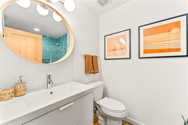 bathroom featuring tasteful backsplash, vanity, and toilet