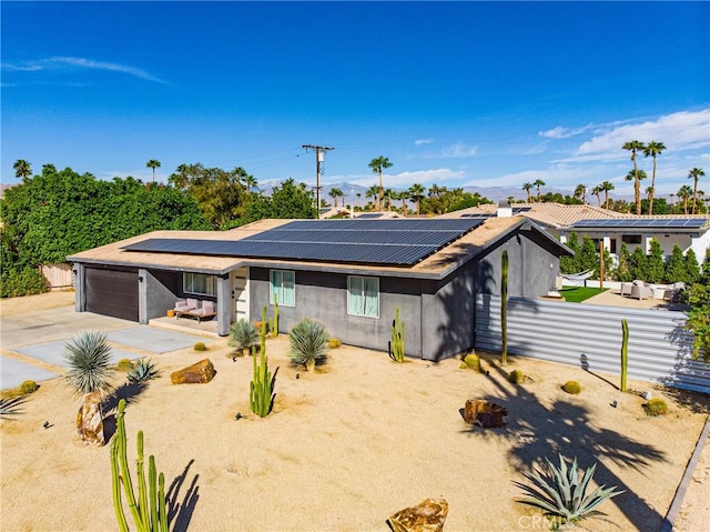 view of front facade with solar panels and a garage