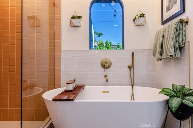 bathroom with a bathing tub and tile walls