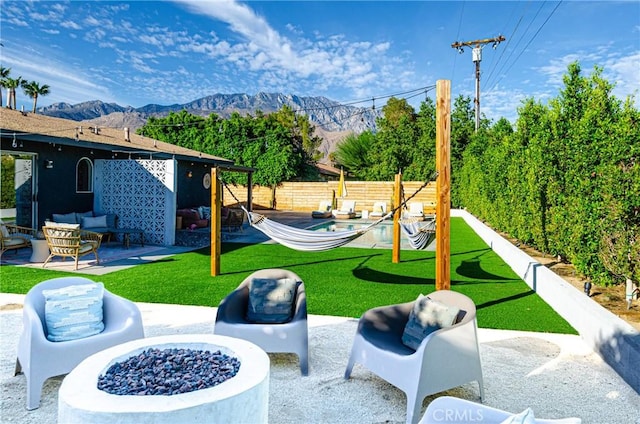 view of patio / terrace with a mountain view and an outdoor living space with a fire pit