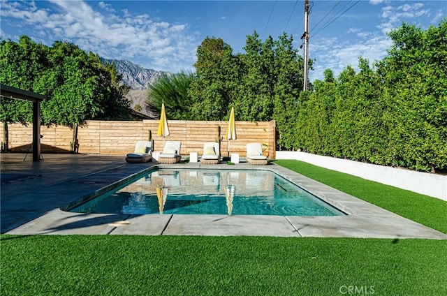 view of pool featuring a mountain view, a yard, and a patio