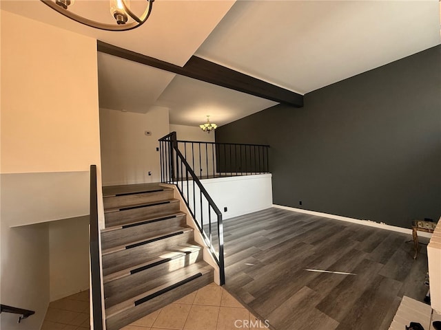 staircase featuring hardwood / wood-style flooring, a notable chandelier, and beamed ceiling