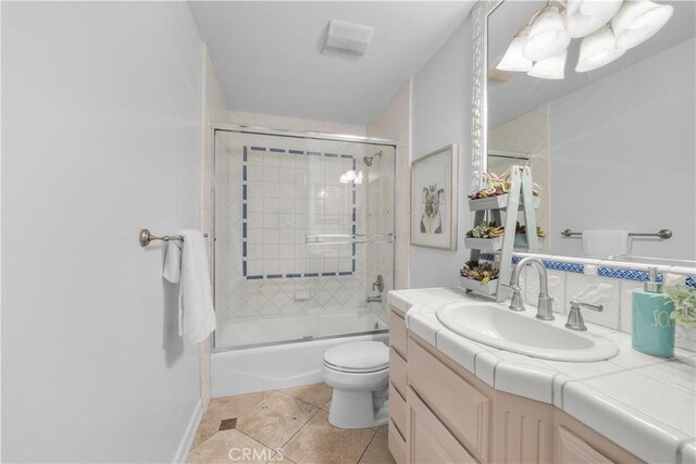 full bathroom with vanity, toilet, enclosed tub / shower combo, and tile patterned flooring