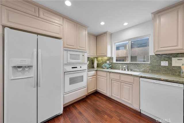 kitchen with decorative backsplash, light stone counters, dark hardwood / wood-style floors, sink, and white appliances