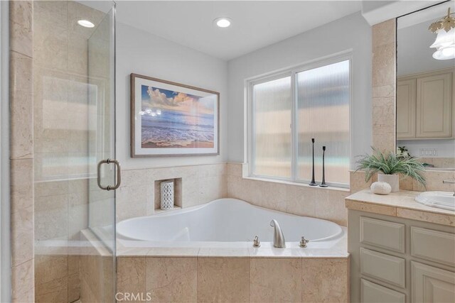 bathroom with vanity, independent shower and bath, and plenty of natural light