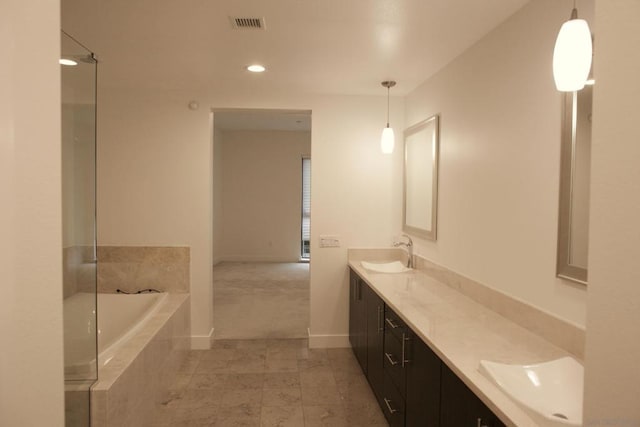 bathroom featuring vanity and tiled tub