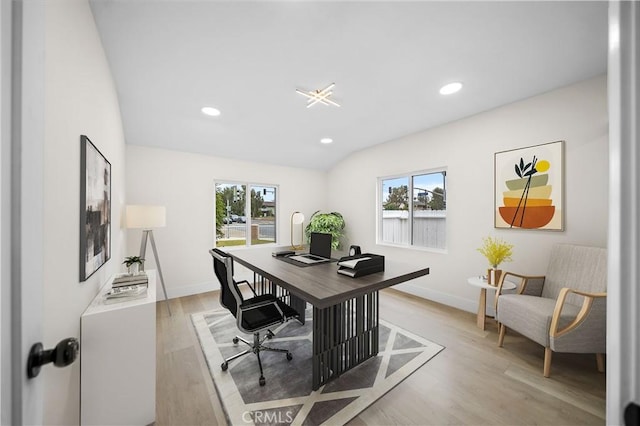 office space with lofted ceiling and light wood-type flooring