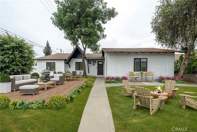 back of property with outdoor lounge area, a yard, and a wooden deck