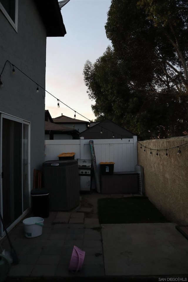 patio terrace at dusk featuring grilling area