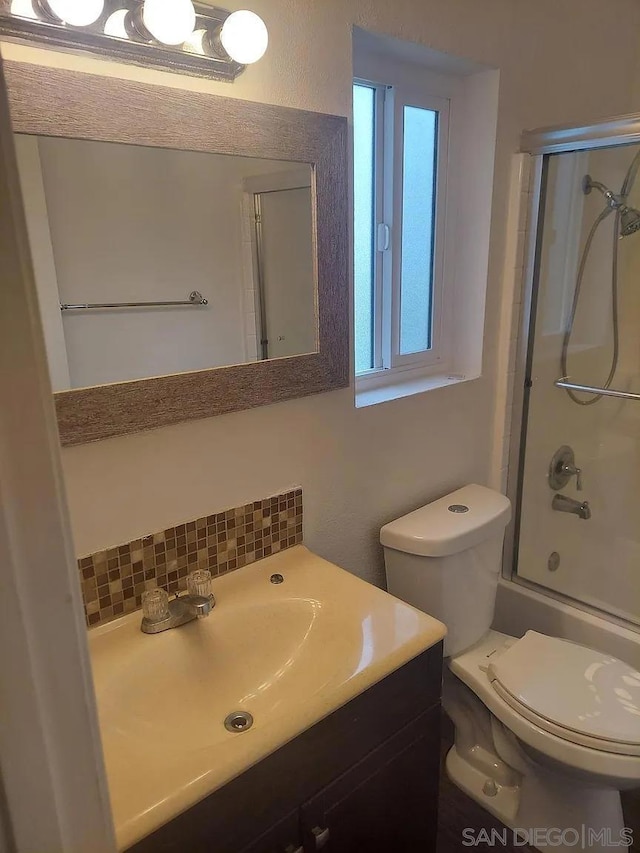 full bathroom with vanity, toilet, enclosed tub / shower combo, and decorative backsplash