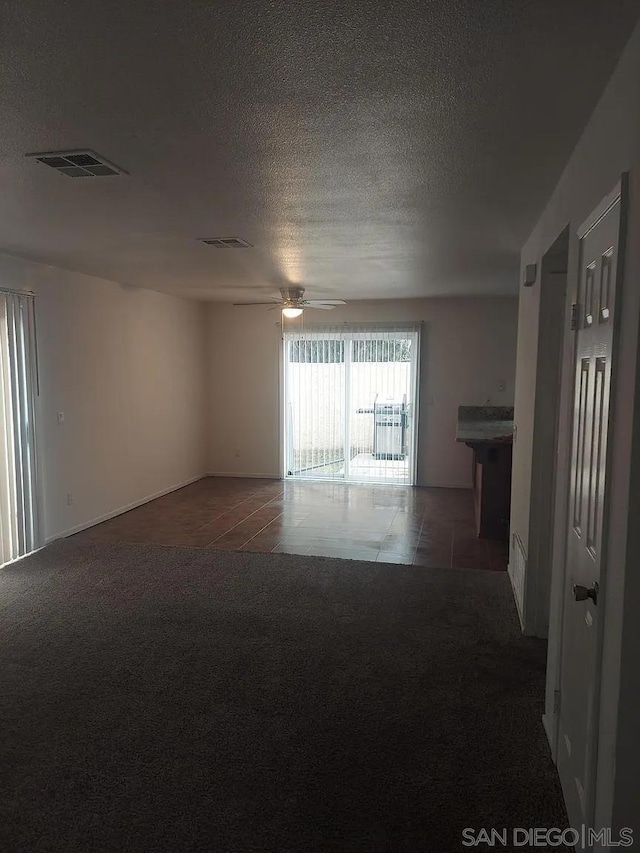 carpeted empty room featuring a textured ceiling and ceiling fan