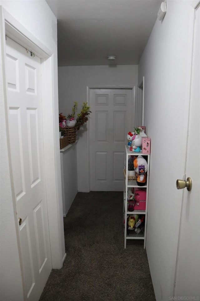 hallway featuring dark colored carpet