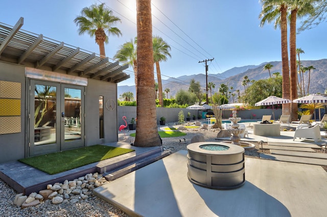 view of patio featuring a mountain view, french doors, and a fire pit