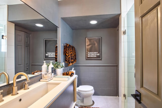 bathroom featuring tile patterned flooring, vanity, tile walls, and toilet