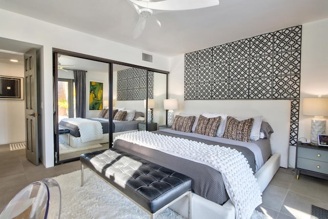 bedroom with ceiling fan, a closet, and light tile patterned floors