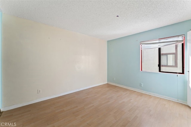 empty room featuring light hardwood / wood-style floors and a textured ceiling