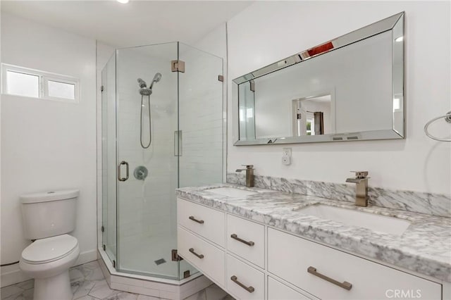 bathroom with toilet, vanity, and a shower with door