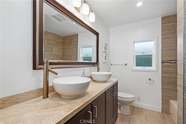 bathroom featuring toilet, vanity, and hardwood / wood-style flooring