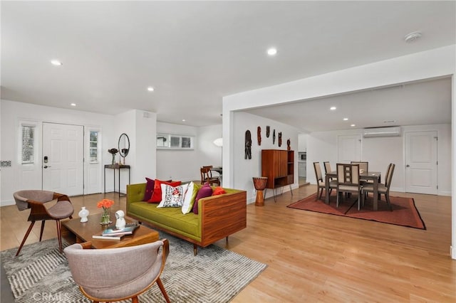 living room with light hardwood / wood-style floors and a wall mounted air conditioner