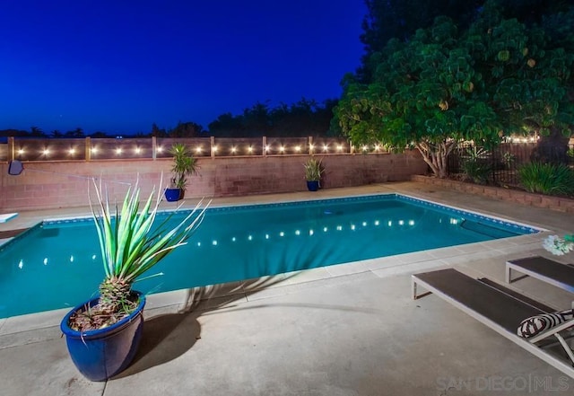 view of pool at twilight