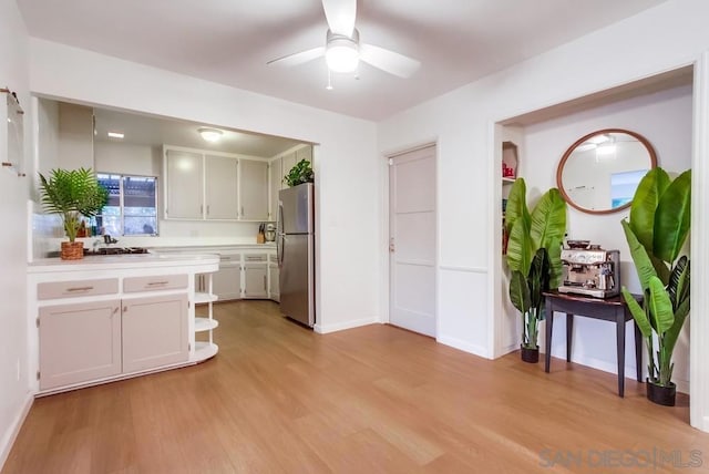 kitchen featuring ceiling fan, white cabinetry, light wood-type flooring, and stainless steel refrigerator