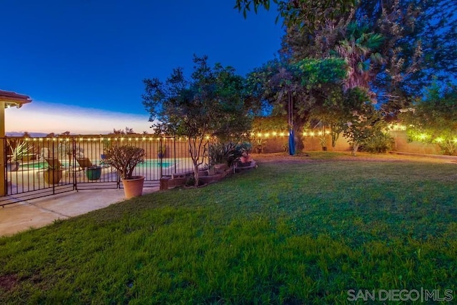 yard at dusk with a fenced in pool