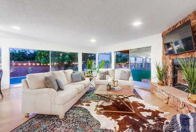 living room with a fireplace and light wood-type flooring