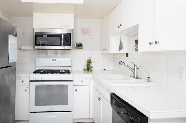 kitchen featuring white cabinets, appliances with stainless steel finishes, tasteful backsplash, and sink