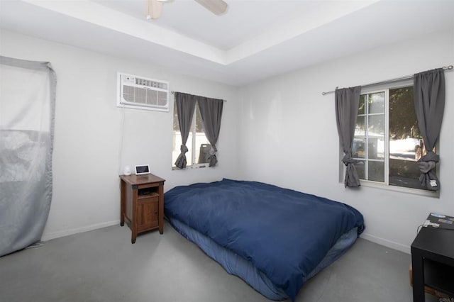 bedroom with a wall unit AC and ceiling fan