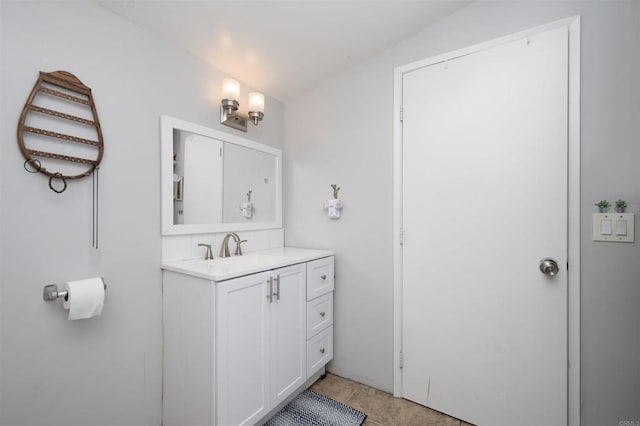 bathroom featuring tile patterned flooring, vanity, and vaulted ceiling