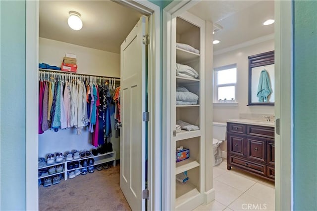 spacious closet featuring sink and light tile patterned floors