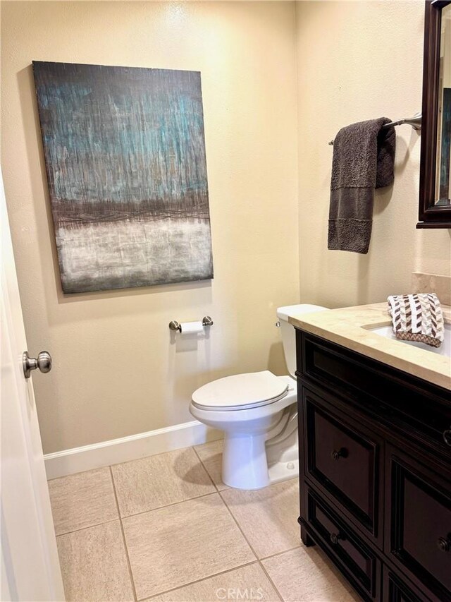 bathroom featuring tile patterned floors, toilet, and vanity