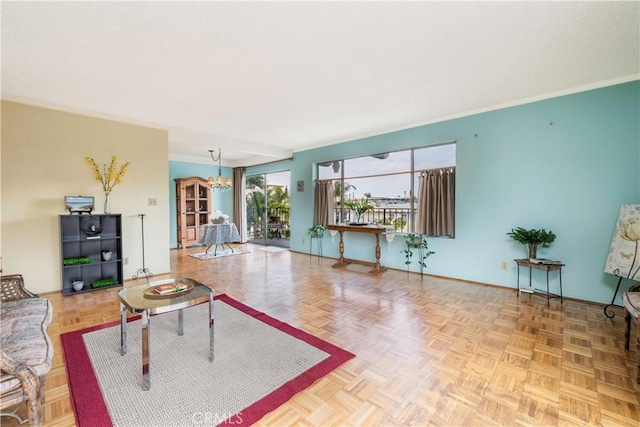 living room with a chandelier, baseboards, and crown molding