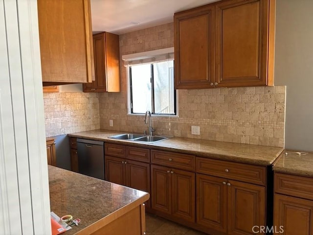 kitchen with decorative backsplash, sink, stainless steel dishwasher, and tile patterned flooring