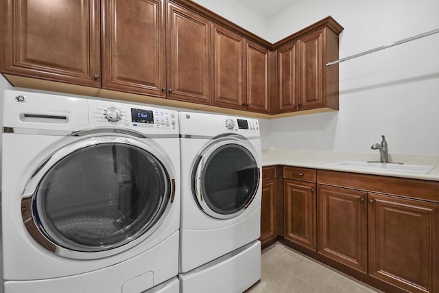 washroom featuring cabinets, sink, and washing machine and clothes dryer