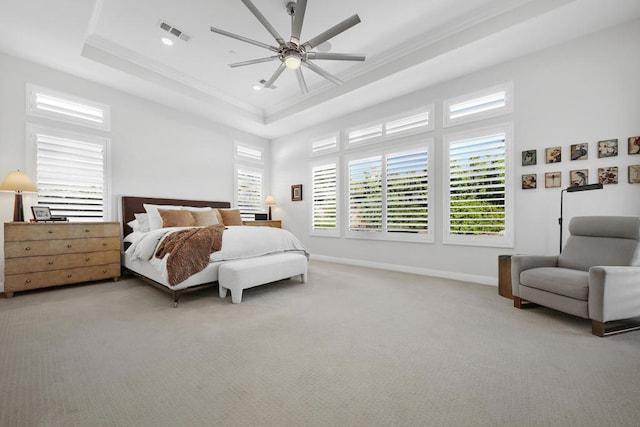 bedroom featuring ceiling fan, light carpet, a tray ceiling, and crown molding