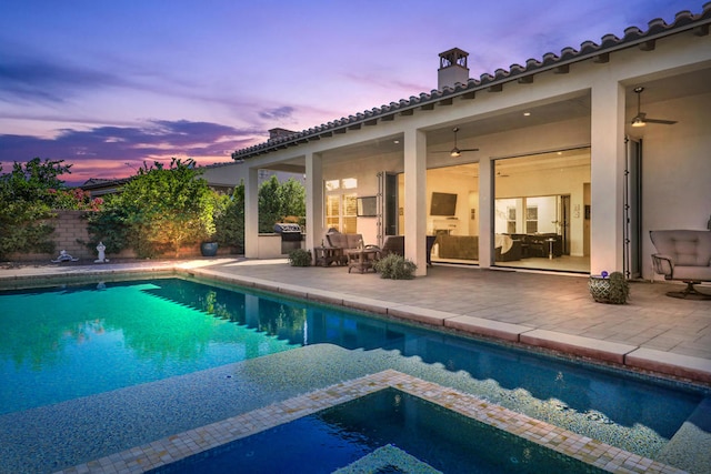 pool at dusk with a patio area