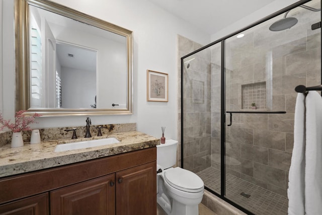 bathroom featuring vanity, walk in shower, and toilet