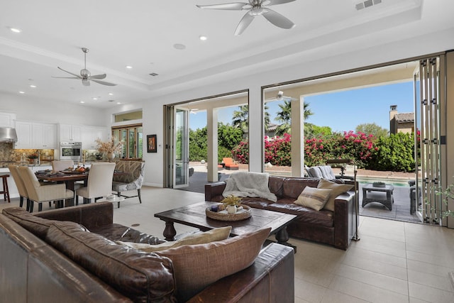 tiled living room featuring a tray ceiling and ceiling fan