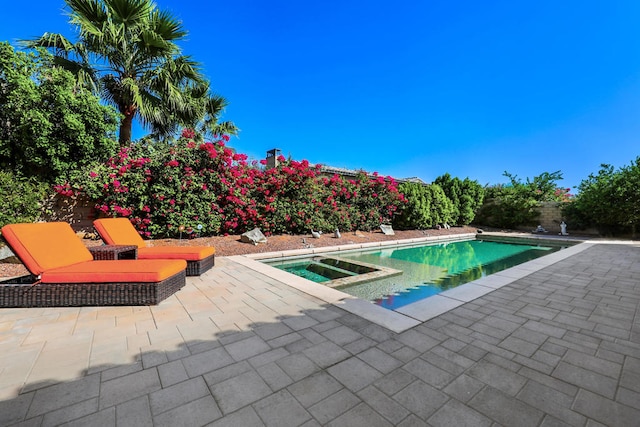 view of swimming pool with an in ground hot tub and a patio area