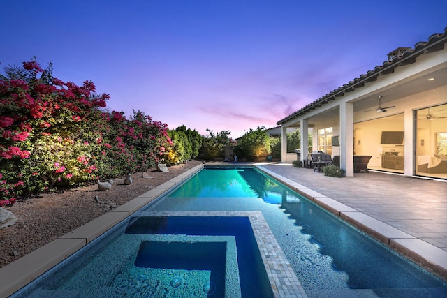 pool at dusk featuring a patio