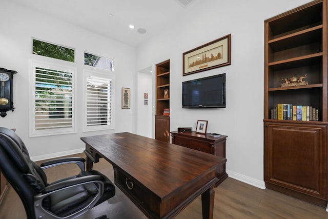 home office with dark hardwood / wood-style floors and built in features