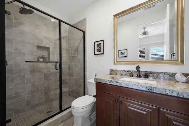 bathroom with vanity, ceiling fan, toilet, and an enclosed shower