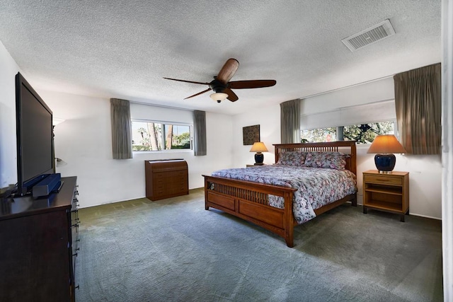 carpeted bedroom featuring ceiling fan and a textured ceiling