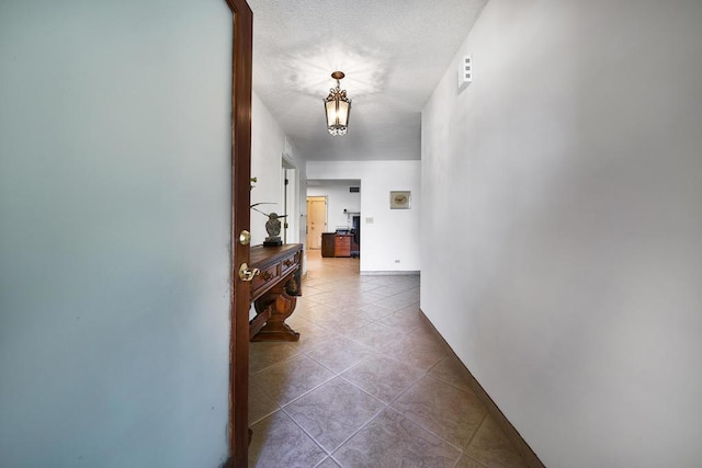 hall with tile patterned flooring and a textured ceiling