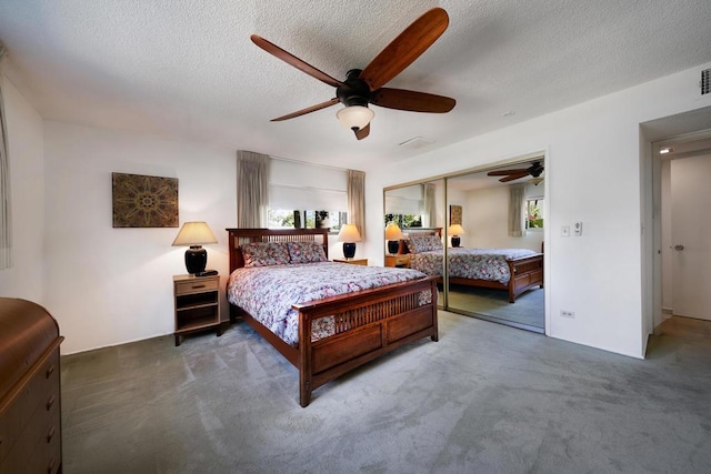 bedroom with a textured ceiling, dark carpet, a closet, and ceiling fan