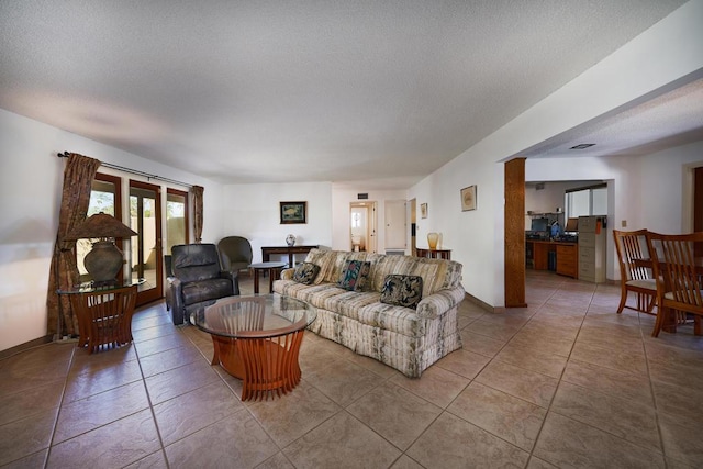 living room featuring light tile patterned flooring and a textured ceiling